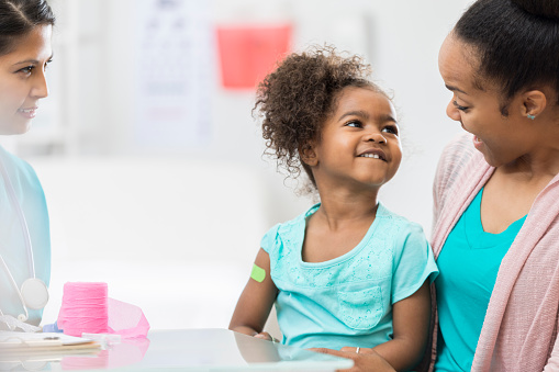 Smiling child with mother at a healthcare clinic near Anketell, showcasing the excellent medical facilities available at Catena Estate